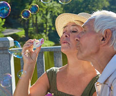 Old people with bubble blower. Couple of seniors.